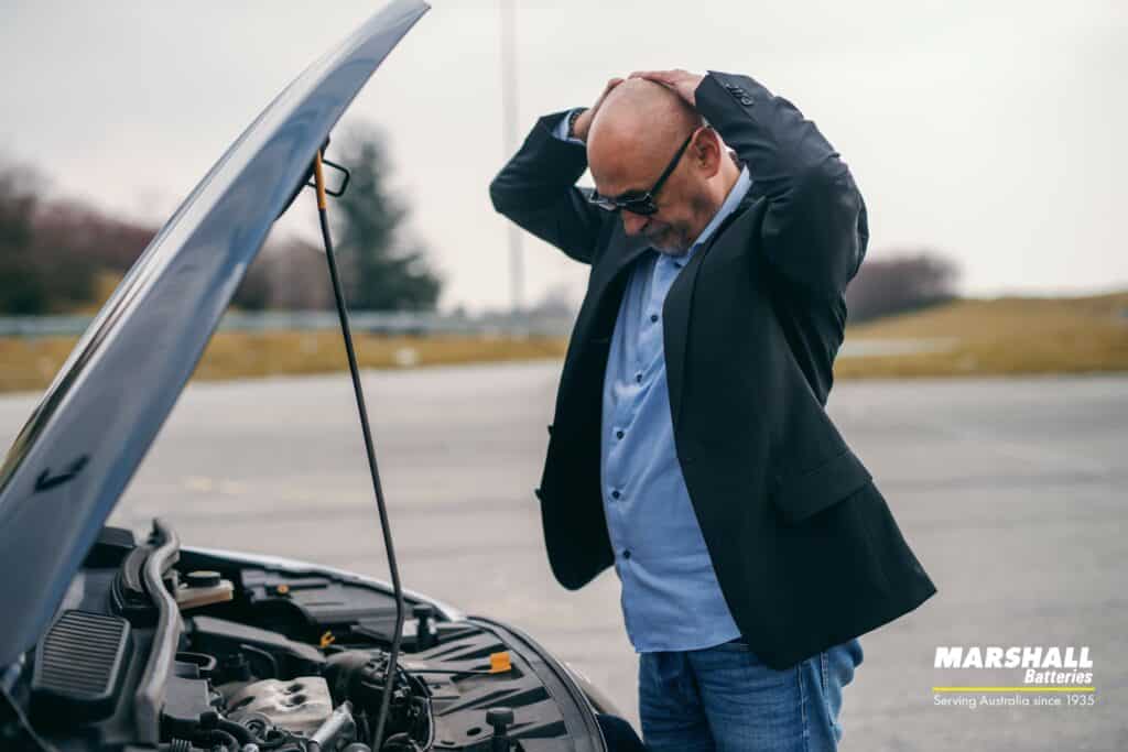 man frustrated with car broken down and in need of roadside assistance service