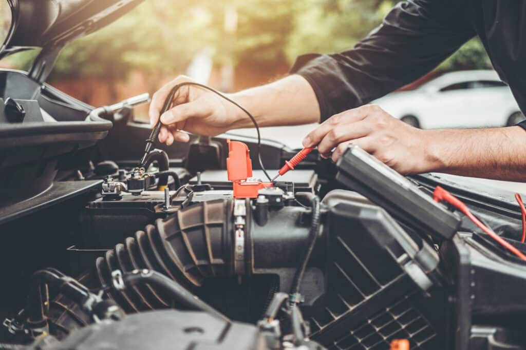 Auto mechanic working in garage Technician Hands of car mechanic working in auto repair Service and Maintenance car battery check.